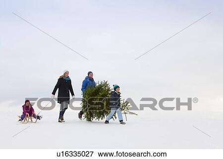 Stock Photo - Family walking together in snow. Fotosearch