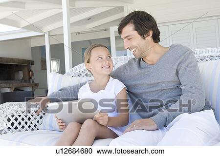 Stock Image - Father and daughter using tablet. Fotosearch