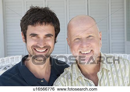 Father and son sitting on sofa View Large Photo Image Stock Photograph - Father and son sitting on sofa. Fotosearch