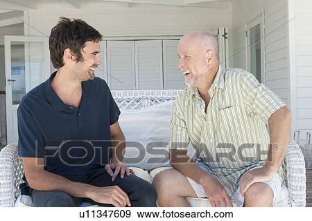 Father and son talking on sofa View Large Photo Image Stock Photo - Father and son talking on sofa. Fotosearch