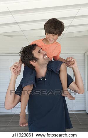 Father carrying son on shoulders View Large Photo Image Stock Image - Father carrying son on shoulders. Fotosearch