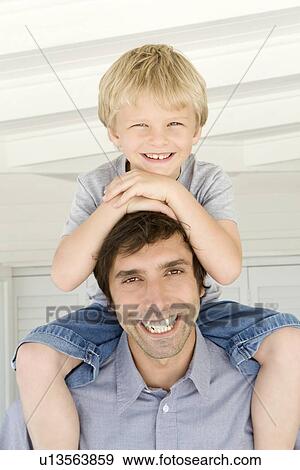 Stock Photo - Father carrying son on shoulders. Fotosearch