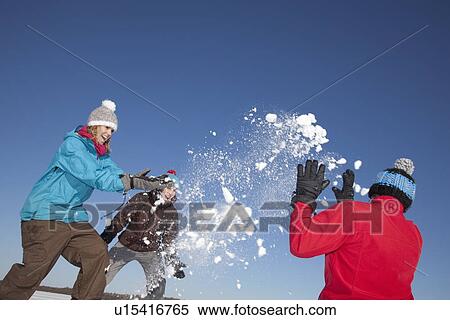 Stock Photography - Friends having snowball fight outdoors. Fotosearch