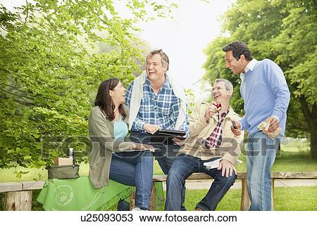 Friends using tablet computer in park View Large Photo Image Stock Image - Friends using tablet computer in park. Fotosearch