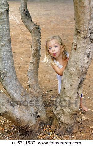 Girl playing in tree in park View Large Photo Image Stock Image - Girl playing in tree in park. Fotosearch