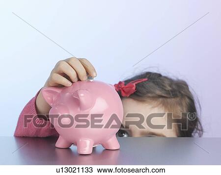 Girl putting coin in piggy bank View Large Photo Image Stock Image - Girl putting coin in piggy bank. Fotosearch