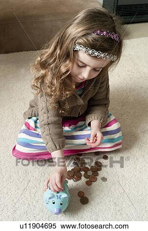 Girl putting coins in piggy bank View Large Photo Image Stock Photography - Girl putting coins in piggy bank. Fotosearch