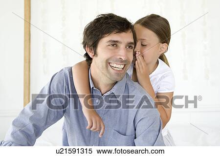 Stock Photography - Girl whispering to smiling father. Fotosearch