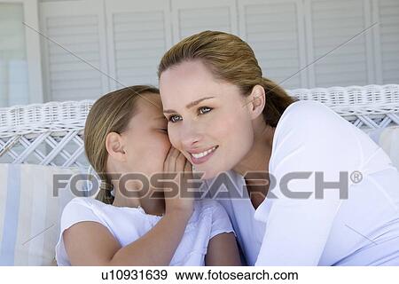Girl whispering to smiling mother View Large Photo Image Stock Photo - Girl whispering to smiling mother. Fotosearch