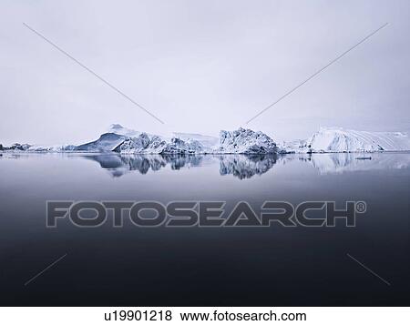 Stock Photo - Glaciers reflected in still lake. Fotosearch