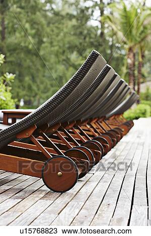 Lawn chairs lined up on wooden deck View Large Photo Image Stock Image - Lawn chairs lined up on wooden deck. Fotosearch