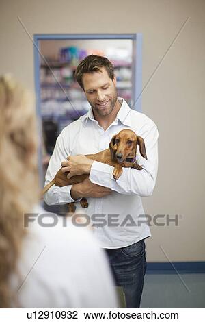 Man bringing dog to veterinarian View Large Photo Image Stock Image - Man bringing dog to veterinarian. Fotosearch