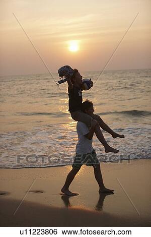 Man carrying daughter on shoulders View Large Photo Image Stock Photograph - Man carrying daughter on shoulders. Fotosearch
