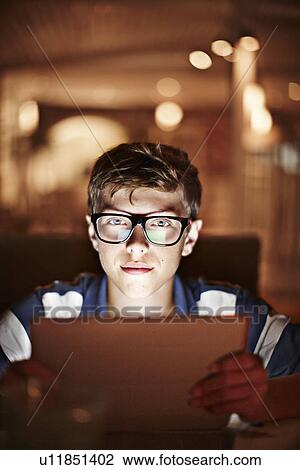 Man illuminated by tablet computer View Large Photo Image Stock Image - Man illuminated by tablet computer. Fotosearch