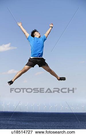 Man jumping for joy over wind turbines View Large Photo Image Stock Photo - Man jumping for joy over wind turbines. Fotosearch