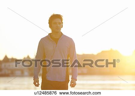 Man listening to headphones outdoors View Large Photo Image Stock Photograph - Man listening to headphones outdoors. Fotosearch