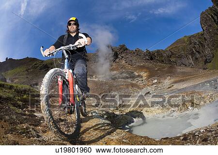 Man riding mountain bike near geyser View Large Photo Image Stock Image - Man riding mountain bike near geyser. Fotosearch