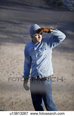 Man shielding eyes from sun outdoors View Large Photo Image Stock Photo - Man shielding eyes from sun outdoors. Fotosearch