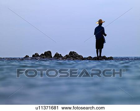 Man standing on rocks in ocean View Large Photo Image Stock Image - Man standing on rocks in ocean. Fotosearch