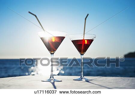 Martinis with straws on table outdoors View Large Photo Image Stock Photo - Martinis with straws on table outdoors. Fotosearch