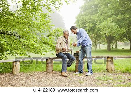 Men talking in park View Large Photo Image Stock Photo - Men talking in park. Fotosearch
