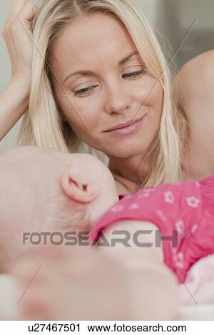 Mother and baby laying on bed View Large Photo Image Stock Image - Mother and baby laying on bed. Fotosearch