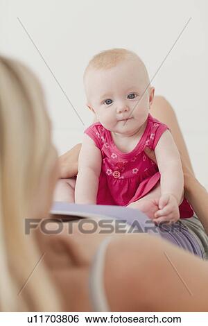 Mother and baby sitting on bed View Large Photo Image Stock Photograph - Mother and baby sitting on bed. Fotosearch