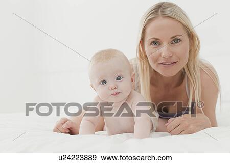 Mother and baby smiling on bed View Large Photo Image Stock Photo - Mother and baby smiling on bed. Fotosearch