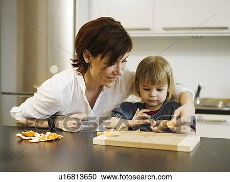 Mother and daughter peeling orange View Large Photo Image Stock Image - Mother and daughter peeling orange. Fotosearch