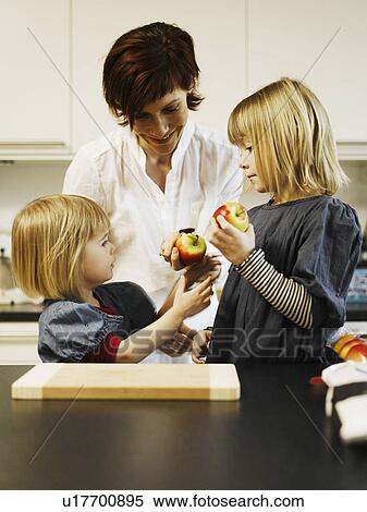 Mother and daughters eating in kitchen View Large Photo Image Stock Photography - Mother and daughters eating in kitchen. Fotosearch