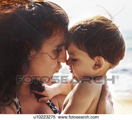 Stock Photography - Mother and toddler kissing on beach. Fotosearch