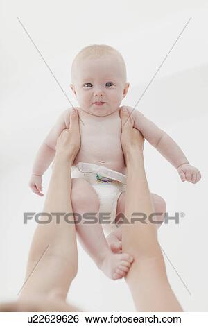 Stock Photograph - Mother lifting baby in air. Fotosearch