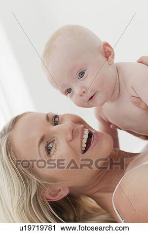 Mother playing with baby on bed View Large Photo Image Stock Image - Mother playing with baby on bed. Fotosearch