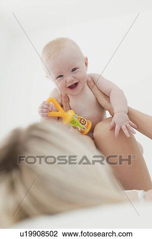 Mother playing with baby on bed View Large Photo Image Stock Image - Mother playing with baby on bed. Fotosearch