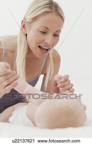 Mother playing with baby on bed View Large Photo Image Stock Image - Mother playing with baby on bed. Fotosearch