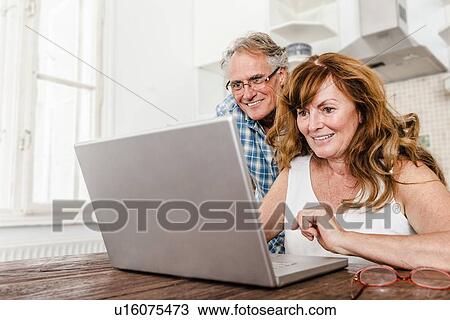 Older couple using laptop in kitchen View Large Photo Image Stock Image - Older couple using laptop in kitchen. Fotosearch