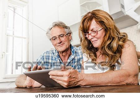 Stock Image - Older couple using tablet computer. Fotosearch