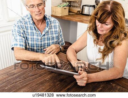 Older couple using tablet computer View Large Photo Image Stock Photo - Older couple using tablet computer. Fotosearch