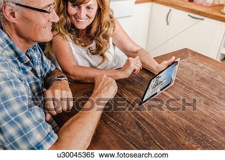 Stock Photography - Older couple using tablet computer. Fotosearch