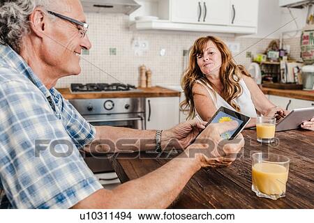 Older couple using tablet computers View Large Photo Image Picture - Older couple using tablet computers. Fotosearch