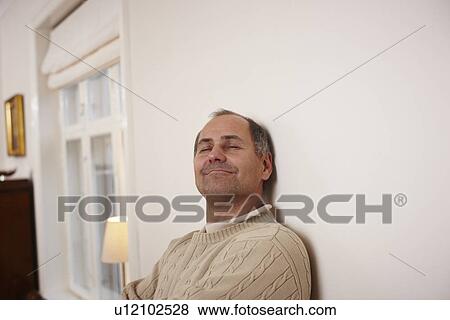 Stock Photo - Older man relaxing in home. Fotosearch