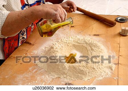 Stock Image - Older woman baking on wooden board. Fotosearch