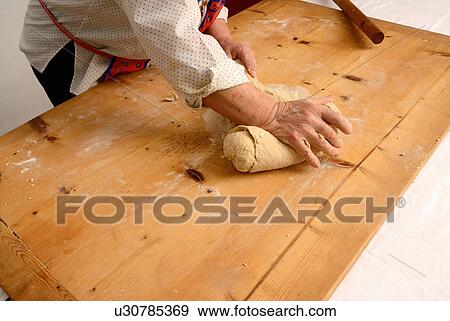 Stock Photo - Older woman kneading dough on board. Fotosearch