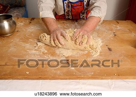 Stock Photograph - Older woman kneading dough on board. Fotosearch