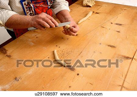 Stock Photo - Older woman making pasta from dough. Fotosearch