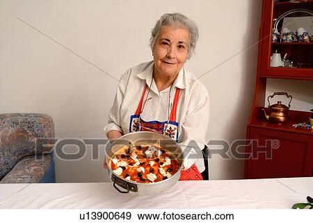 Older woman making pizza in living room View Large Photo Image Stock Photo - Older woman making pizza in living room. Fotosearch