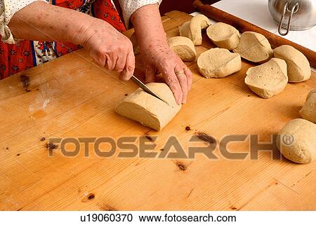 Older woman slicing dough on board View Large Photo Image Stock Image - Older woman slicing dough on board. Fotosearch