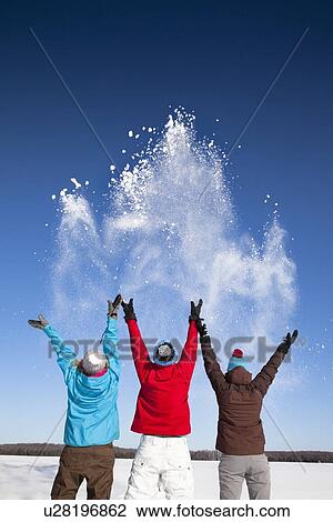 Stock Image - People playing with snow in field. Fotosearch