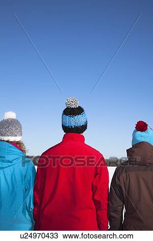 Stock Image - People wearing hats and coats in snow. Fotosearch