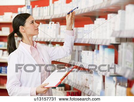 Pharmacist browsing medicine on shelves View Large Photo Image Stock Image - Pharmacist browsing medicine on shelves. Fotosearch